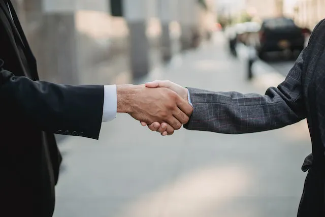 Shaking hands business suits
